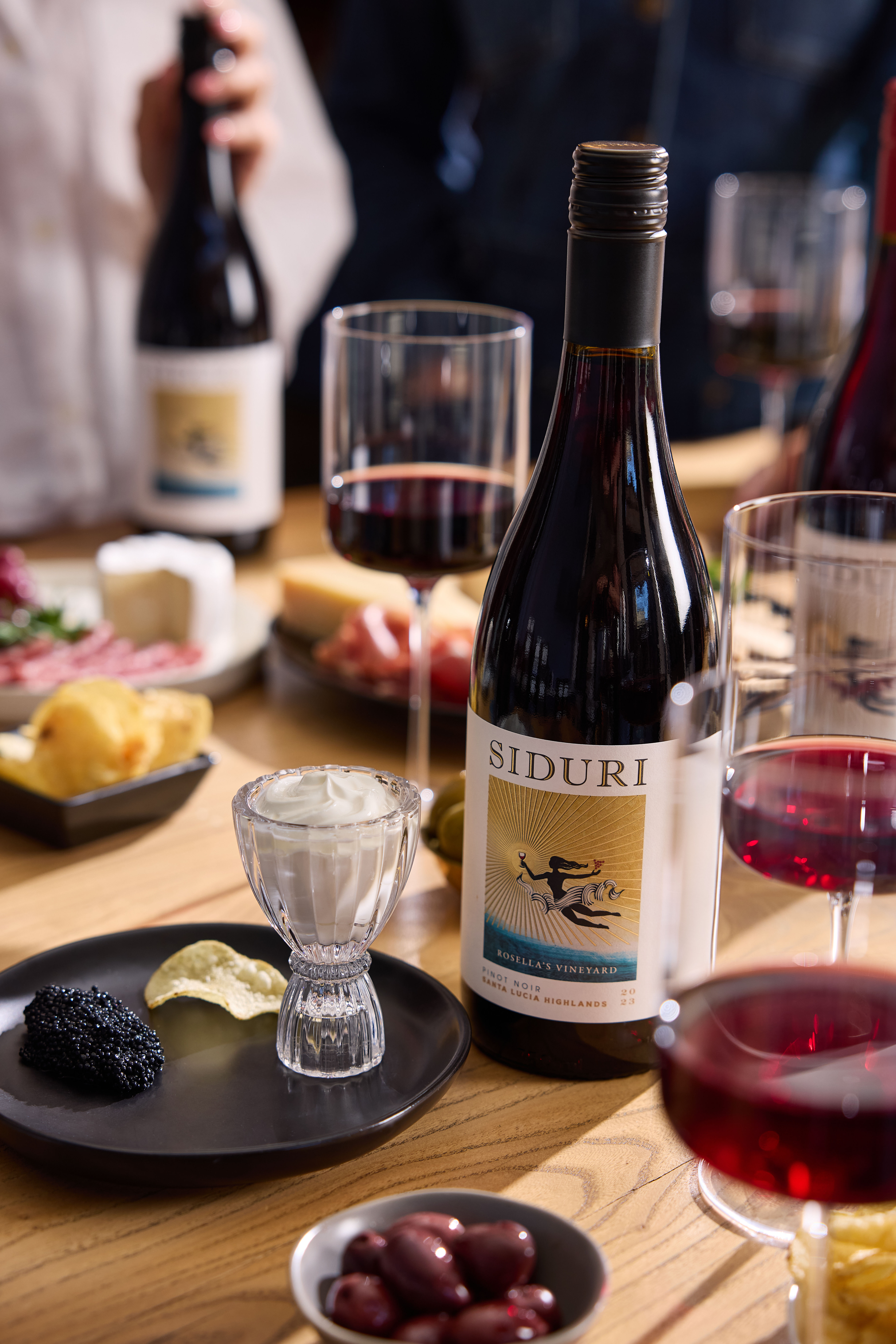 Picture of Rosella's Vineyard Pinot Noir on a table with caviar and potato chips.