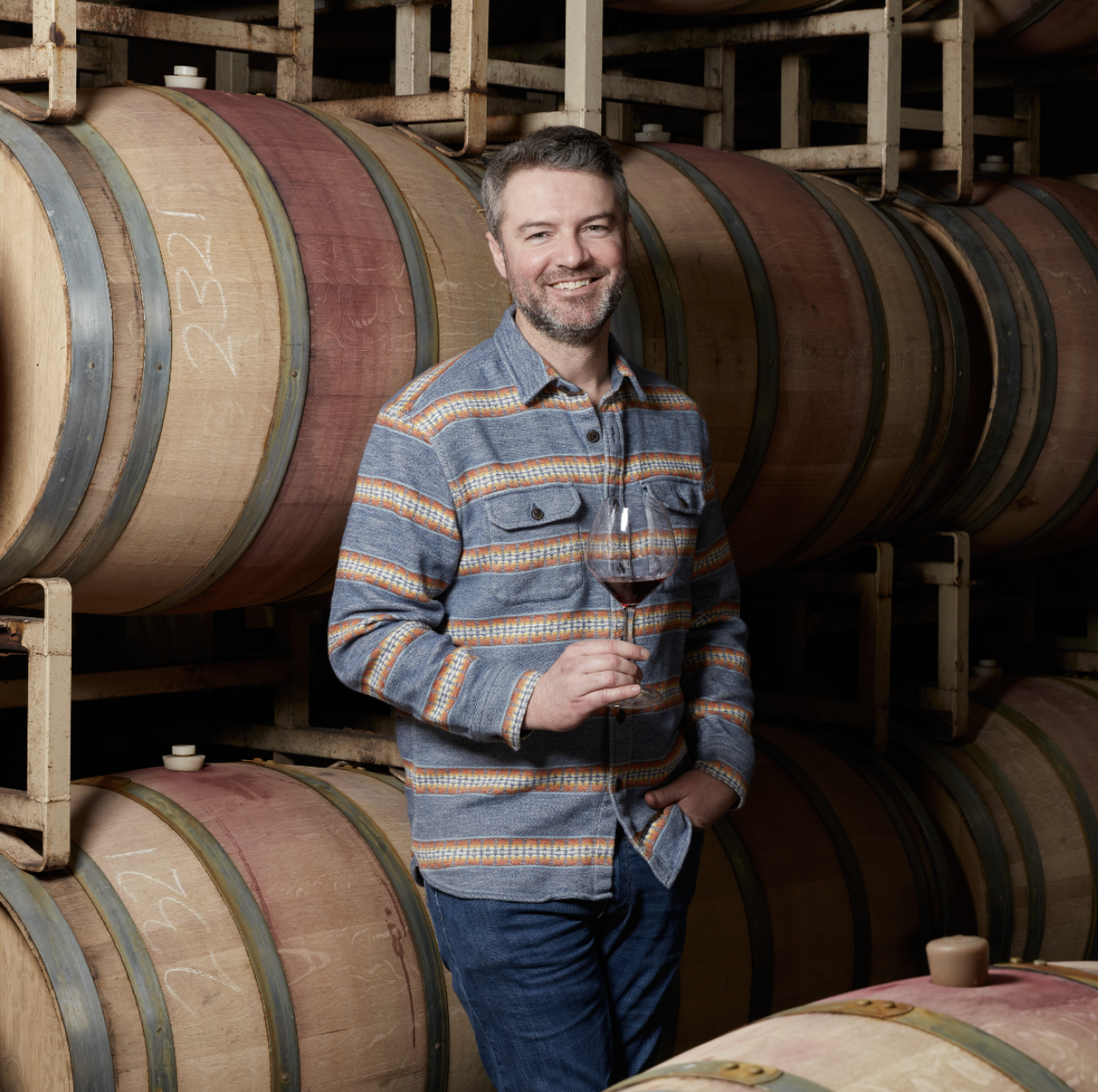 Matt holding Wine glass in barrel room